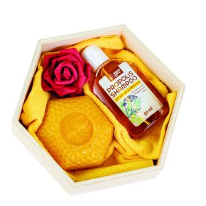 Geschenkset mit Wachskerze in Form einer Waben und Akazien-Honig Haarshampoo gepackt mit Deko-Rose und gelbem Waschhandschuh in einer Holzwabe