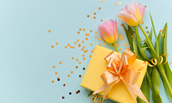 Tulpen Konfetti und ein gelbes Geschenk. Kategoriebild Geschenksets